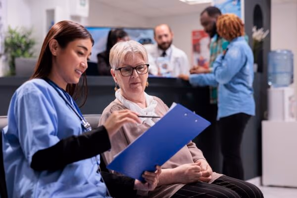 nurse explaining diagnosis to elderly patient