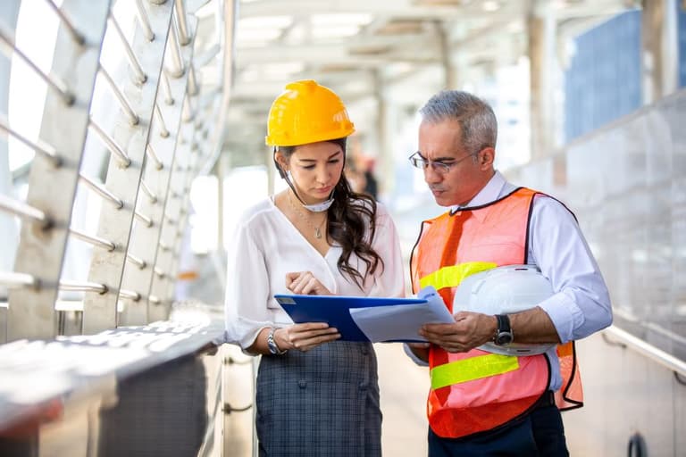 Two workers reviewing incident reports
