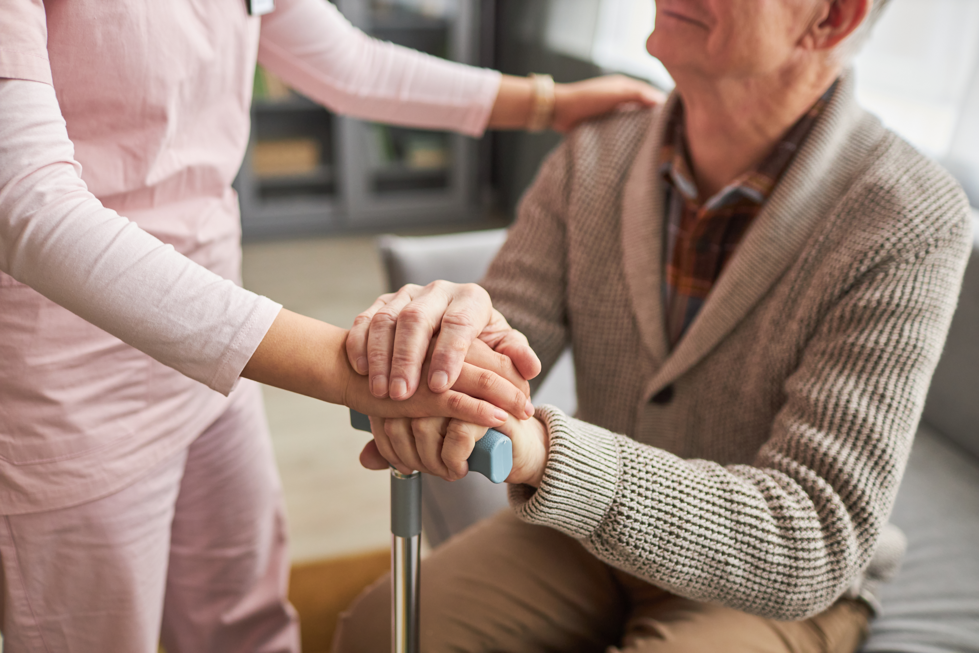 A caring hand holding an elderly person's hand, highlighting the duty of care towards vulnerable populations