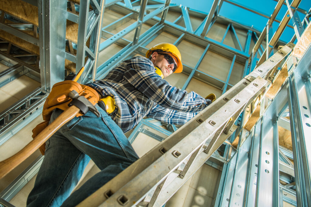 Construction worker stepping up an extension ladder