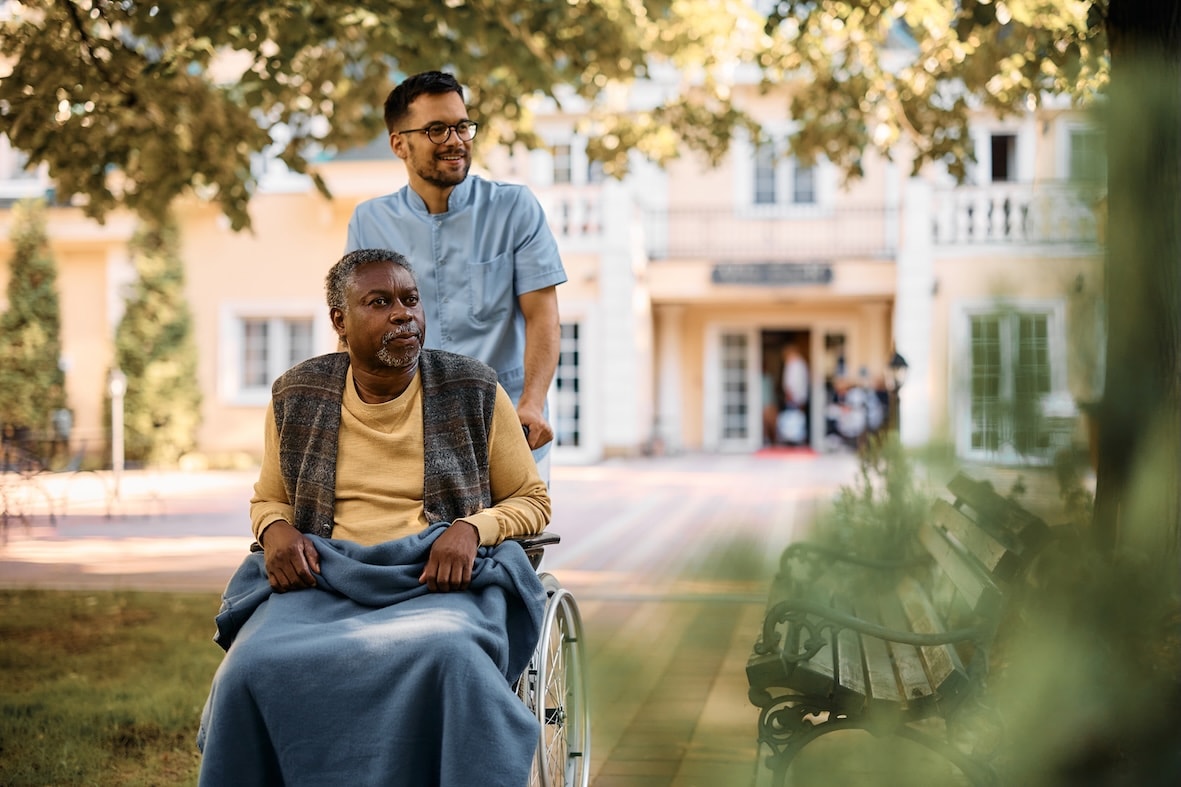 carer-wheeling-man-in wheelchair