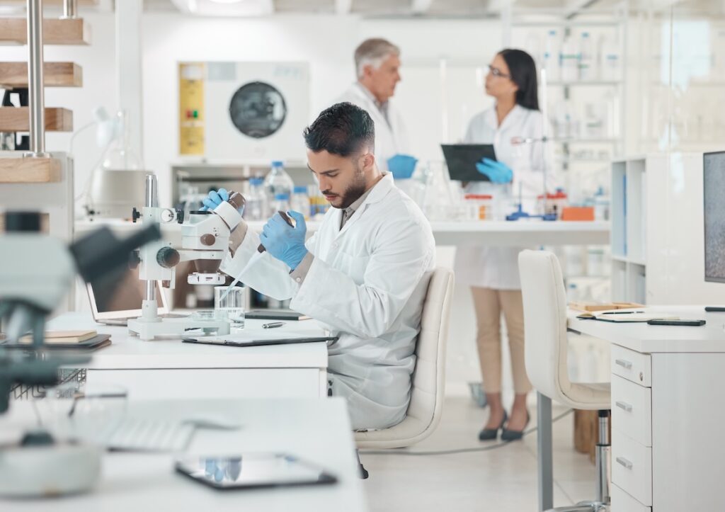 Three scientists adhering to health and safety in the laboratory