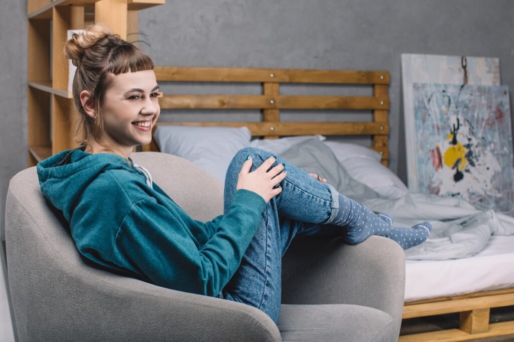 girl sitting in armchair in supported accommodation